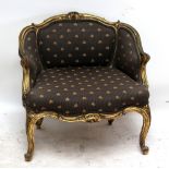 A late 19th century French upholstered bowl back armchair with scrolling gilt frame and knee carved