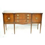 A reproduction mahogany sideboard with two cupboard doors flanking three drawers in concave middle