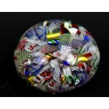 A Clichy clear glass and scrambled latticino decorated paperweight, diameter 5cm.