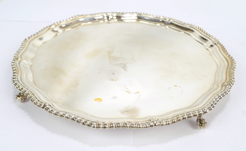 An Elizabeth II hallmarked silver salver with shaped gadrooned rim on four ball and claw feet,