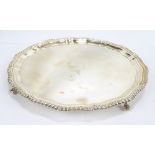 An Elizabeth II hallmarked silver salver with shaped gadrooned rim on four ball and claw feet,