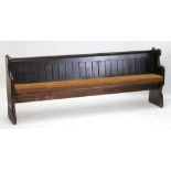 A Victorian pine pew with shaped ends, width 231cm.