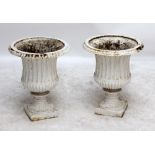 A pair of white painted cast iron campana shaped garden urns, height 51cm.