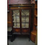 An Edwardian mahogany and inlaid display cabinet with twin glazed doors above tapering supports,