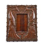 An early 20th century copper fronted photo frame embossed with a pair of stylised peacocks on