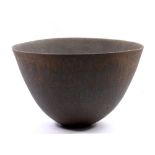 JOHN WARD (born 1938); a large deep stoneware bowl covered in streaky matt bronze glaze,