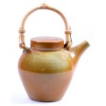 GWYN HANSSEN (PIGOTT) (1935-2013); a stoneware teapot with cane handle, speckled tan glaze,