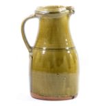 RICHARD BATTERHAM (born 1936); a stoneware jug covered in green ash glaze, height 30cm.