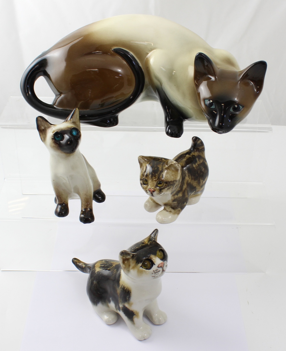 Three Winstanley cats with paperweight glass eyes and an associated Siamese cat,