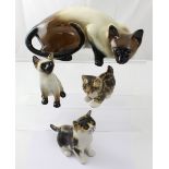 Three Winstanley cats with paperweight glass eyes and an associated Siamese cat,