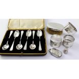 A cased set of six hallmarked silver teaspoons and four silver napkin rings,