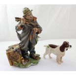 A Capodimonte figure group of an old man patching his jacket, stood next to a tea chest,