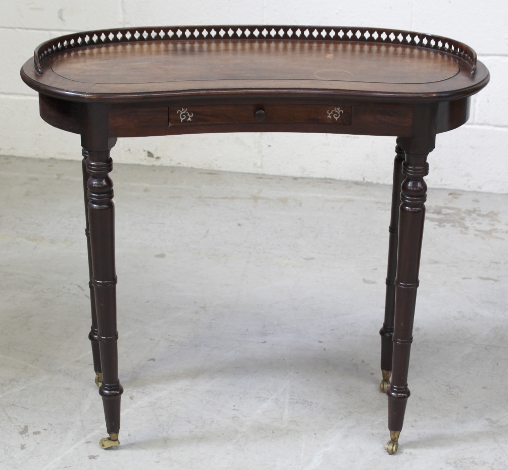 A Victorian walnut kidney-shaped table with galleried top, to turned supports and castors,