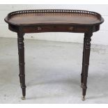 A Victorian walnut kidney-shaped table with galleried top, to turned supports and castors,