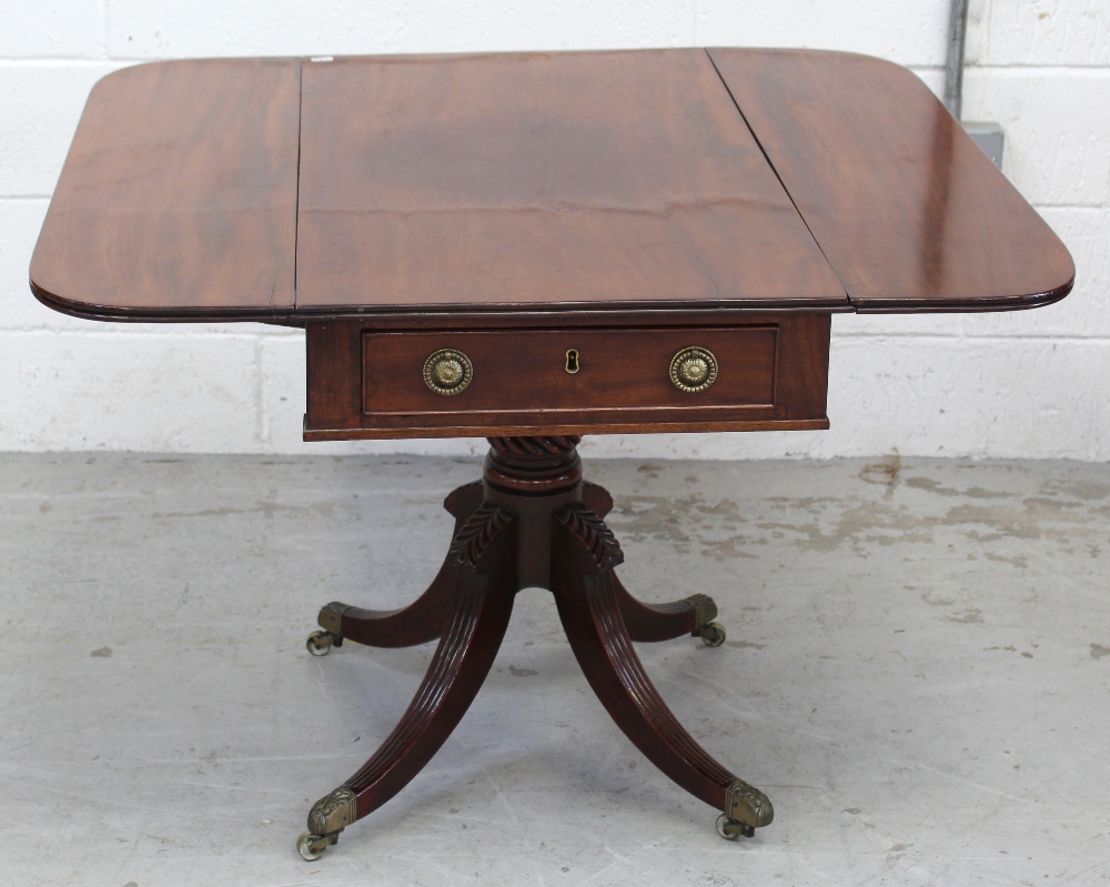 A Regency mahogany Pembroke table, central carved column to quadripartite supports on castors,