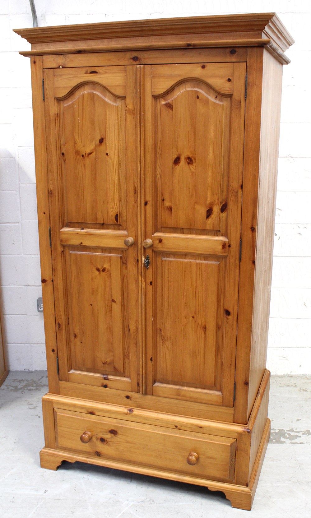 A two-door pine wardrobe above single-drawer, 185 x 91cm.