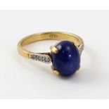An 18ct yellow gold star sapphire cabochon ring, with shoulder-set chip diamonds, size L 1/2,
