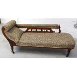 An Edwardian oak floral upholstered chaise longue on ring-turned supports to castors, length 170cm.