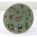 A large 19th century Chinese export celadon plate with Famille Rose enamel decoration of peonies