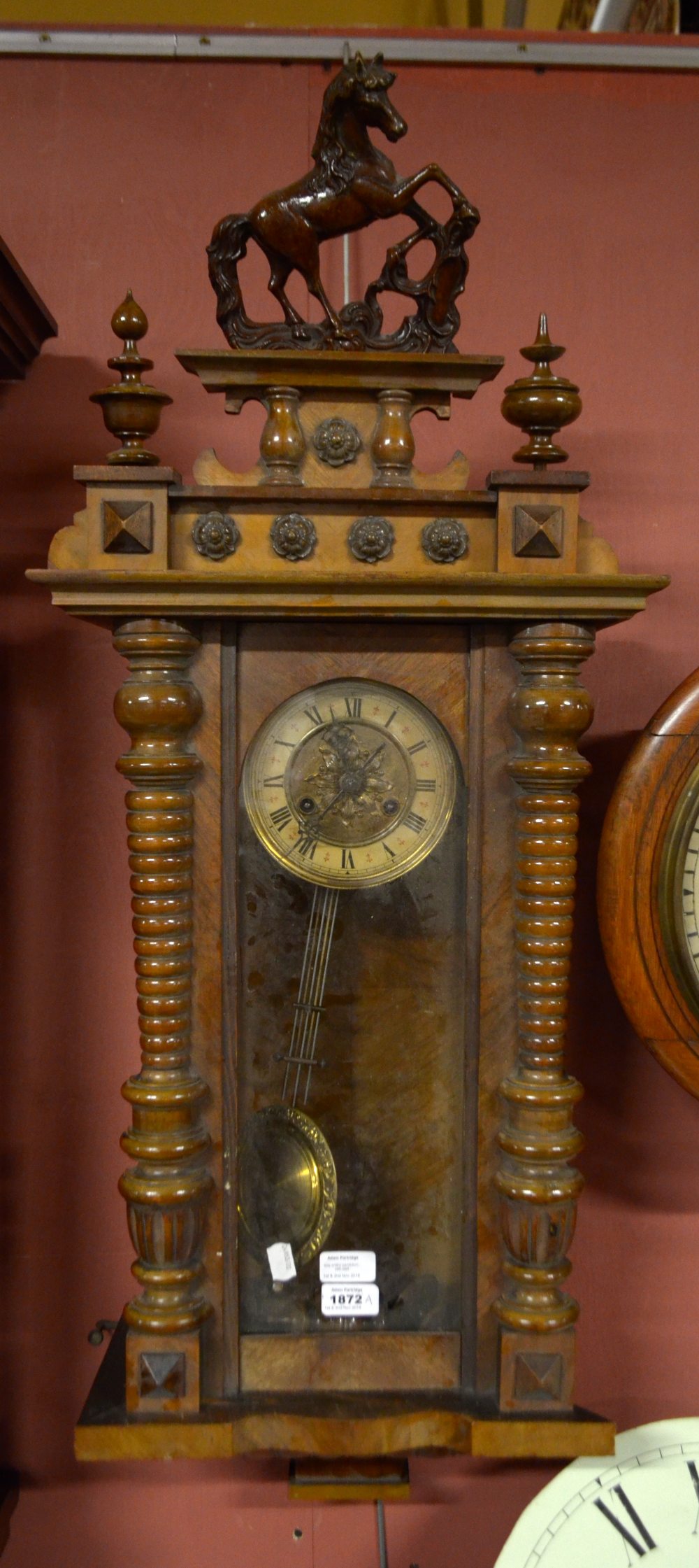 An early 20th century walnut eight day Vienna style wall clock with Roman numerals, length 81cm.