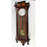 A circa 1900 walnut beech and ebonised Vienna style wall clock with two-piece white enamel dial set