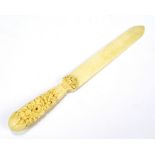 A late 19th century possibly French ivory letter opener with highly carved floral decorated handle,