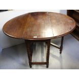 An early 20th century oak drop leaf table on bobbin turned supports, height 73.5cm.