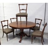 A late 19th century mahogany oval tilt top table on an octagonal column support to quadripartite