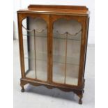 An early-to-mid 20th century walnut display cabinet on ball and claw cabriole legs, height 126cm.