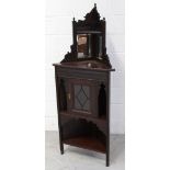 A late Victorian red walnut floor standing corner cabinet with mirrored top and single glazed