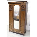 A 1930s oak single wardrobe with glazed door, on turned legs, height 204cm.