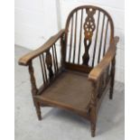 A stained beech William Morris style wheel-back reclining armchair with shaped arms and spindle