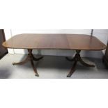 A 20th century reproduction Georgian style mahogany twin pillar dining table on turned supports
