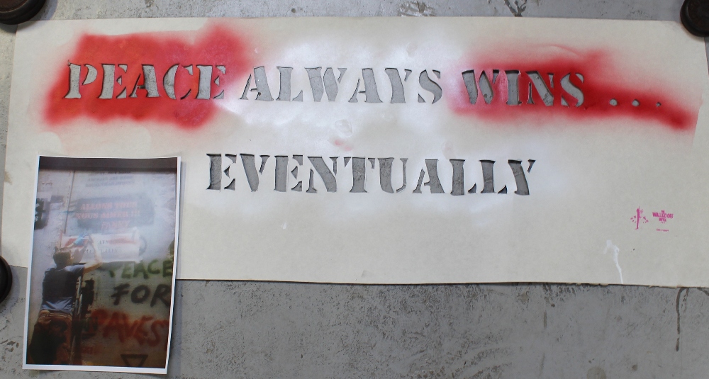 A stencil from Banksy's 'The Walled Off Hotel' entitled 'Peace Always Wins...