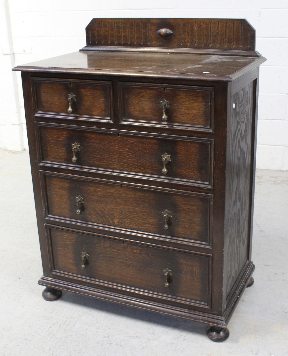 A 1920s oak chest of two short over three long drawers on squat bun feet, width 92cm.