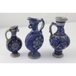 Three small German stoneware jugs of varying design all finished in blue,