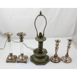 A vintage metal table lamp with twisted stem support and two pairs of silver-plated candlesticks