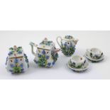 A Dresden miniature forget-me-not floral encrusted tea service comprising two cups and saucers,