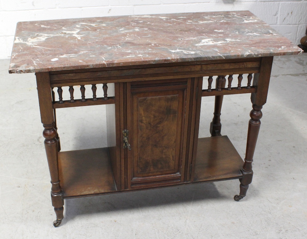 A late Victorian walnut wash stand with marbled top above door.