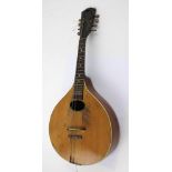 An eight string flat back mandolin in original black Moroccan case, length 62cm.