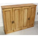 A late 19th century four-door pine wall cupboard with four pine shelves to the interior,