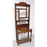 A late Victorian red walnut hall stand with single mirror over bobbin-turned gallery,