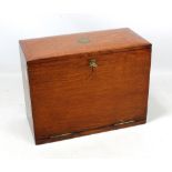 A late Victorian oak stationery box with hinged lid and fall front enclosing fitted purple leather