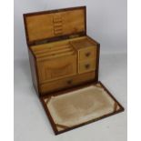 An Edwardian oak travelling stationery cabinet with hinged lid and fall front set with various