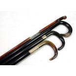 Three ebonised white metal mounted walking sticks, two with horn handles,