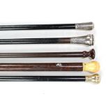 Three ebonised walking sticks to include a foliate scroll engraved silver handled example