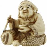 Netsuke des DaikokuJapan Meiji (1868-1912). Elfenbein patiniert. Der sitzende Glücksgott beim