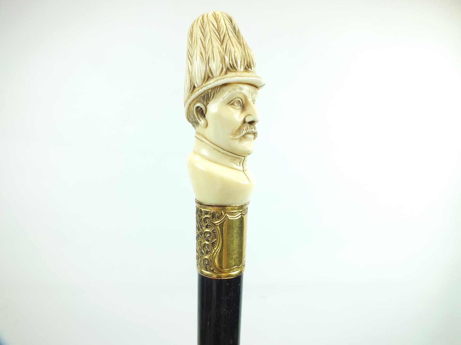 A LATE 19TH/EARLY 20TH CENTURY WALKING CANE, the pommel carved as the head of an officer