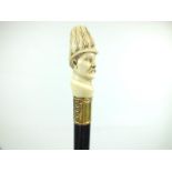 A LATE 19TH/EARLY 20TH CENTURY WALKING CANE, the pommel carved as the head of an officer