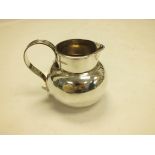 An Edwardian silver jug by George Perkins, London 1904, of plain bulbous form with scroll handle,